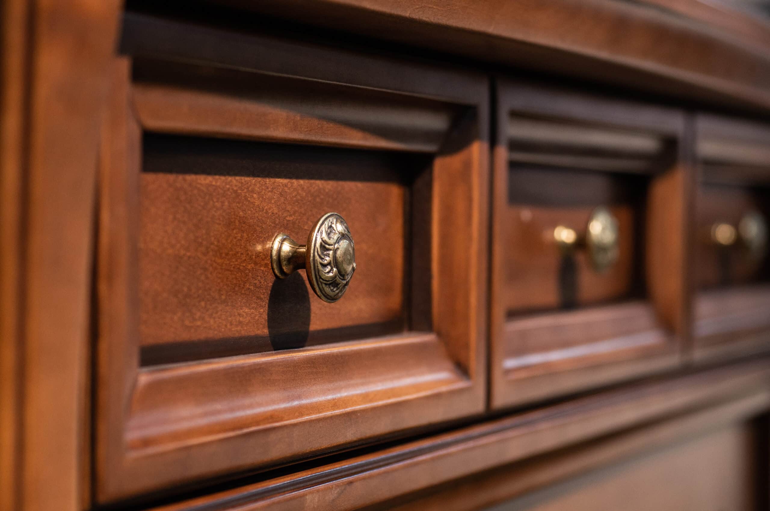 Wooden chest of drawers with metal handles closeup.