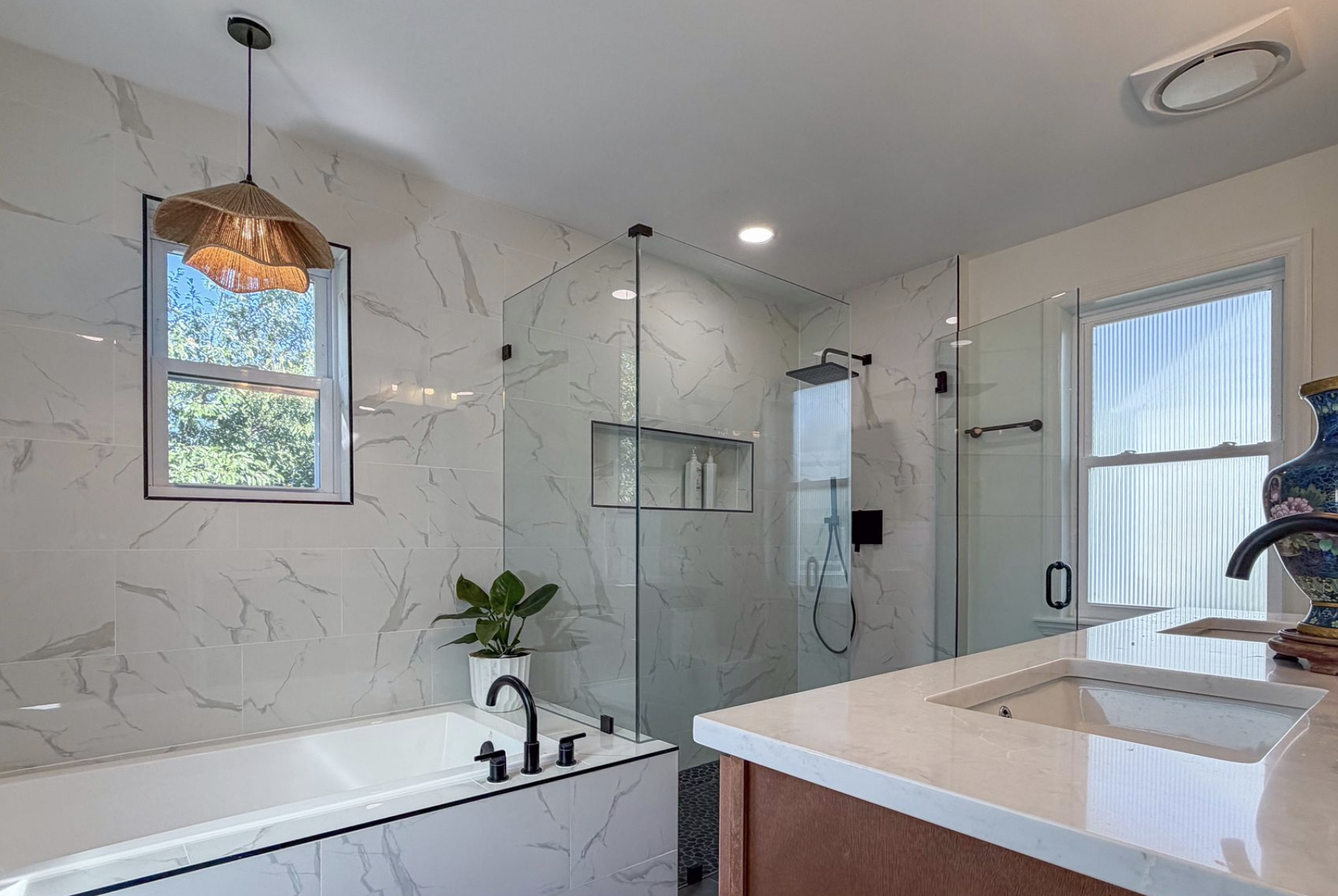 Modern bathroom renovation in Catonsville, Maryland featuring a glass shower and elegant tile design.